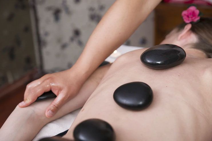 Who may benefit from hot stone massage
